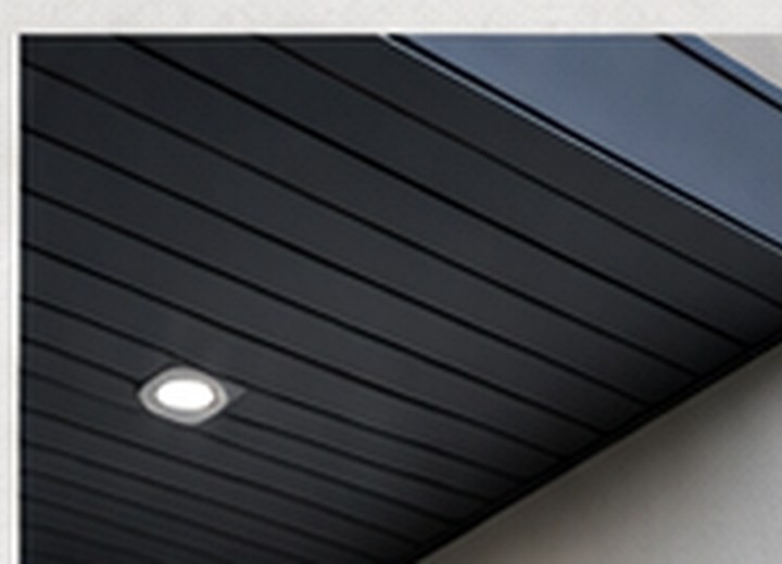 Dark soffit system with recessed lighting under a modern overhang